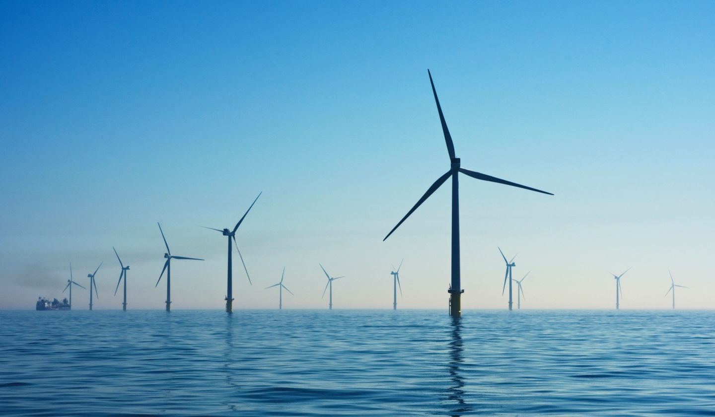 Offshore wind turbines in a calm sea under a clear blue sky